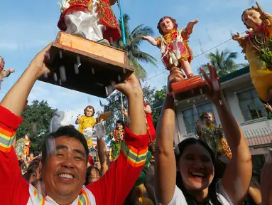 Umat Katolik Roma mengangkat patung simbol Bayi Yesus saat pemberkatan di Manila, Filipina (21/1). Prosesi keagaman tersebut merupakan bagian dari perayaan Santo Nino. (AP Photo / Bullit Marquez)