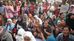 Sejumlah ibu menggelar doa bersama saat ekseksusi penggusuran di kawasan Pasar Ikan, Penjaringan, Jakarta, Senin (11/4). Para warga yang didominasi perempuan itu ikut menolak penggusuran kawasan tersebut. (Liputan6.com/Gempur M Surya)