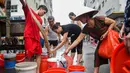 Warga mengisi wadah mereka dengan air dari truk tangki pasokan pemerintah di Hanoi, Vietnam, Kamis (17/10/2019). Pejabat tinggi pemerintah mengonfirmasi bahwa air ledeng di Hanoi tenggara terkontaminasi dengan styrene, suatu zat karsinogenik. (Nhac NGUYEN/AFP)
