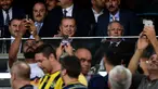 Presiden Turki Recep Tayyip Erdogan (tengah) tersenyum kepada penonton saat menyaksikan pertandingan putaran ketiga kualifikasi UEFA Europa League antara Fenerbahce dan Sturm Graz di Stadion Ulker Fenerbahce di Istanbul (3/8). (AFP Photo/Ozan Kose)