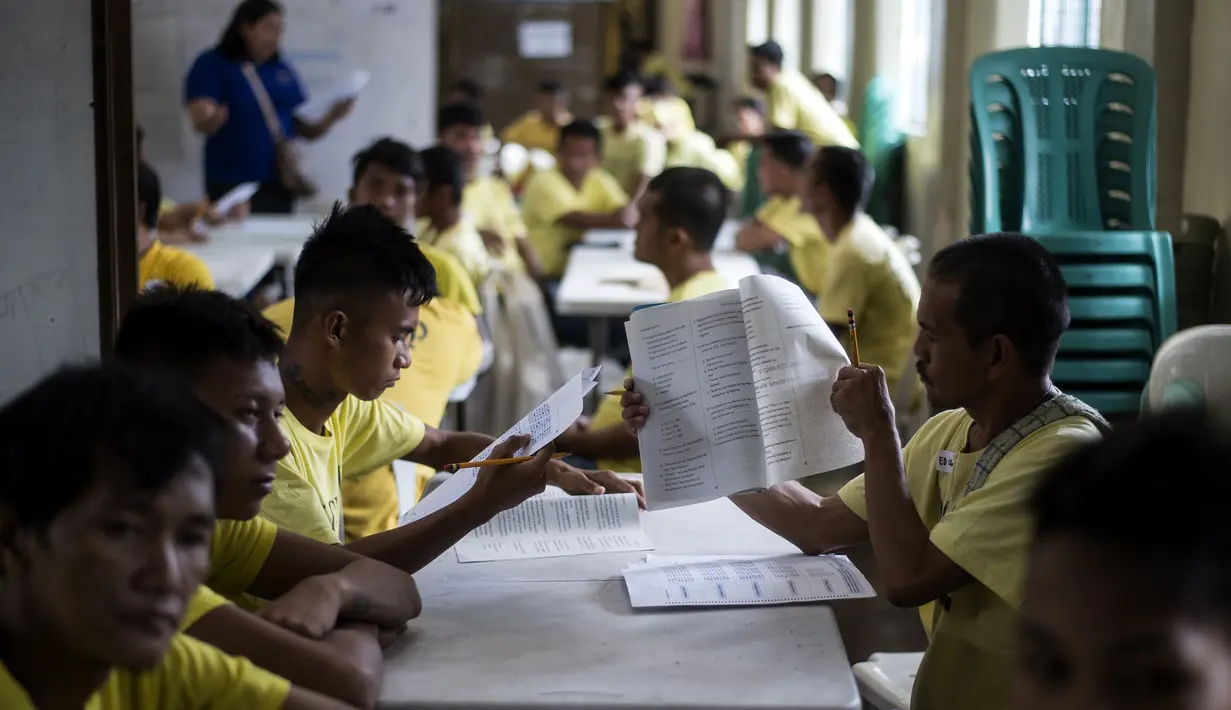 Narapidana mengerjakan soal Ujian Akreditasi Nasional dan Pemeriksaan Kesetaraan di Penjara Manila City, Filipina, Minggu (19/11). Sekitar 900 narapidana mengikuti ujian untuk menjadi modal pendidikan mereka jika bebas dari penjara. (NOEL CELIS/AFP)