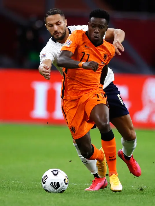 Kiper timnas Italia, Danilo D'Ambrosio berebut bola dengan pemain timnas Belanda, Quincey Promes pada lanjutan UEFA Nations League Grup 1 Liga 1 di Johann Cryuff Arena, Senin (7/9/2020). Italia menang 1-0 saat berkunjung ke markas Belanda. (AP Photo/Peter Dejong)