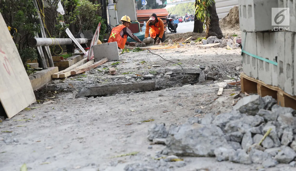 Aktivitas pekerja menyelesaikan proyek revitalisasi trotoar di Jalan Salemba Raya, Jakarta, Jumat (6/9/2019). Proyek revitalisasi trotoar dengan anggaran Rp 75 miliar ini ditargetkan rampung pada Desember mendatang. (Liputan6.com/Helmi Fithriansyah)