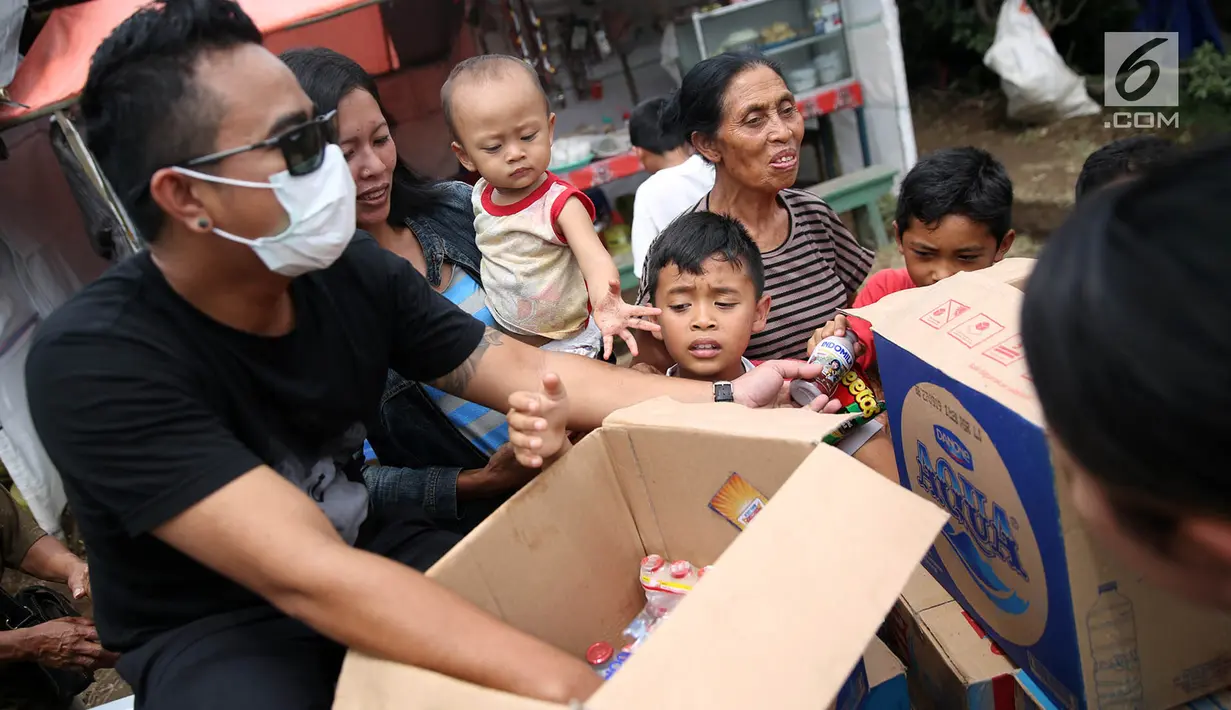 Anak-anak menerima susu kemasan dan makanan ringan dari relawan di sekitar tenda Posko Pengungsi Rendang, Bali, Sabtu (2/12). (Liputan6.com/Immanuel Antonius)