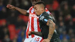 Pemain Manchester City, Gabriel Jesus berebut bola dengan pemain Stoke City, Bruno Martins Indi pada pertandingan pekan ke-30 Premier League di bet365 Stadium, Selasa (13/3). Manchester City sukses menaklukkan Stoke City dengan skor 2-0. (AP/Rui Vieira)