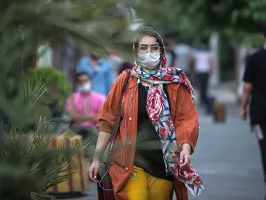 Warga dengan masker melintasi sebuah jalan di pusat Kota Teheran, 28 Juni 2020. Presiden Iran Hassan Rouhani pada Minggu (28/6) mengatakan mengenakan masker di tempat umum akan menjadi wajib mulai pekan depan Di tengah meningkatnya infeksi dan kematian akibat COVID-19. (Xinhua/Ahmad Halabisaz)