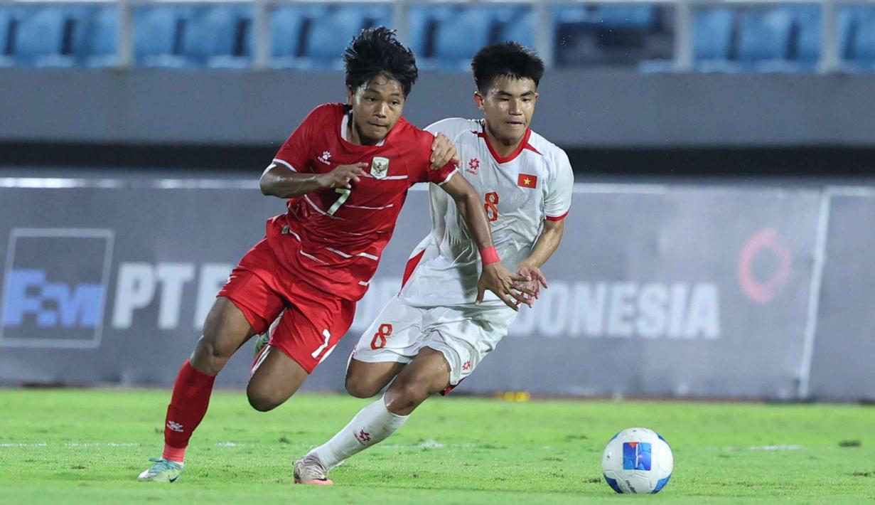 Menghadapi Vietnam U-17 di Stadion Gelora Delta, Sidoarjo, Jawa Timur, Minggu (19/4/2026) malam WIB, Garuda Muda harus puas dengan skor 0-0. Tampak dalam foto, pemain Timnas Indonesia, Dava Yunna Adi Putra (kiri) berebut bola dengan Nguyen Minh Thuy (Vietnam) pada laga Grup A Piala AFF U-17 2026 di Stadion Gelora Delta, Sidoarjo, Jawa Timur, Minggu (19/4/2026) malam WIB. (Bola.com/M Iqbal Ichsan)