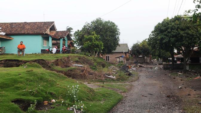 Seorang warga bersantai di halaman rumahnya di dusun Regahan Lada, Pulau Sebesi, Lampung, Senin (31/12). Banyak warga dusun ini yang bertahan dan enggan meninggalkan rumahnya pascatsunami Selat Sunda pada 22 Desember lalu. (Liputan6.com/Herman Zakharia)