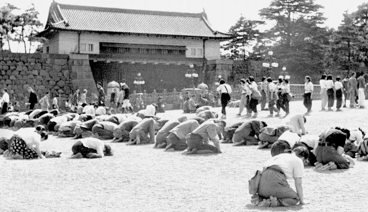 Warga berlutut saat Kaisar Hirohito mengumumkan lewat radio bahwa Jepang telah dikalahkan dalam Perang Dunia II di depan Istana Kekaisaran, Tokyo, Jepang, 15 Agustus 1945. Tanggal 2 September 2020 menjadi peringatan 75 tahun penyerahan resmi Jepang kepada Amerika Serikat.  (Kyodo New via AP, File)