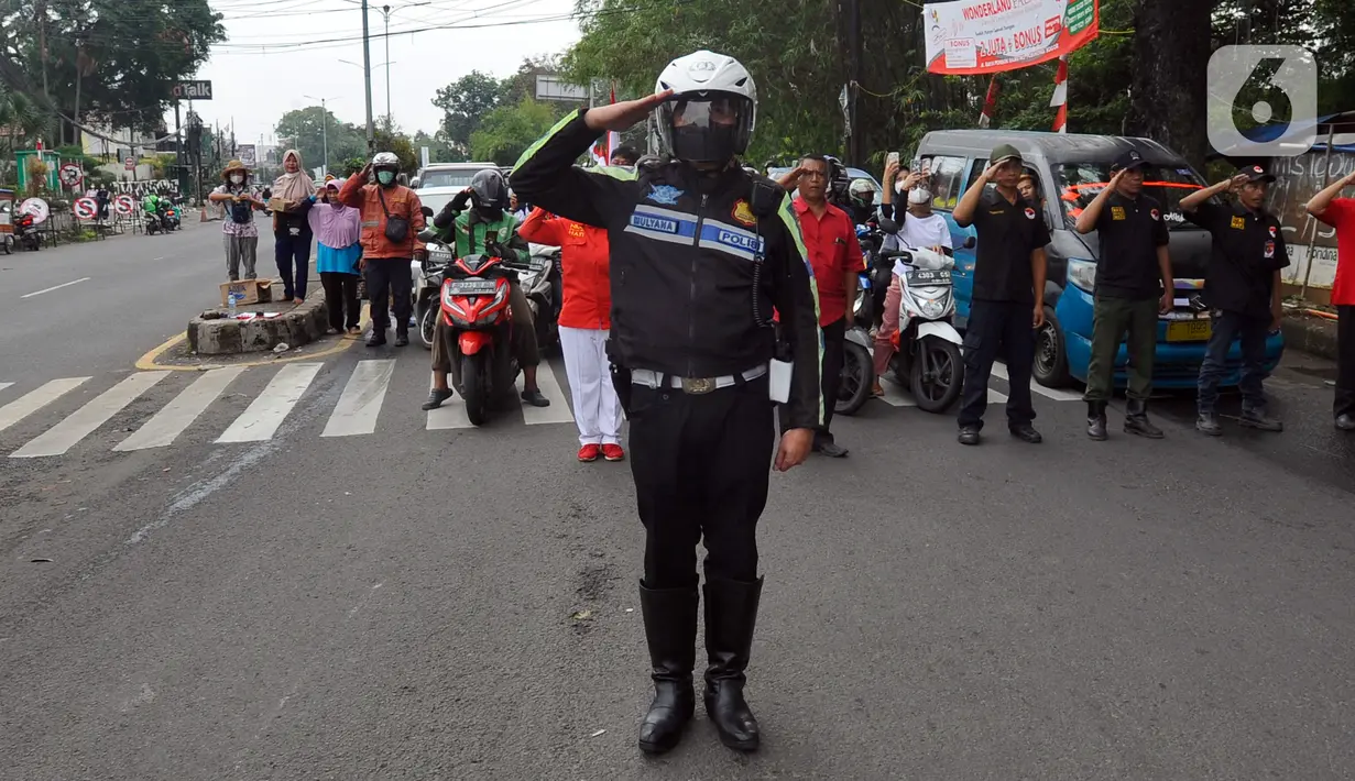 Polisi bersama pengguna jalan melakukan penghormatan saat detik-detik proklamasi 17 Agustus di ruas jalan protokol Jakarta-Bogor, pertigaan Cibinong, Bogor, Jawa Barat, Rabu (17/8/2022). Sejumlah pengguna jalan terlihat turun dari kendaraannya dan melakukan sikap hormat. (merdeka.com/Arie Basuki)