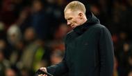 Legenda Manchester United, Paul Scholes, melihat ponselnya sebelum pertandingan Liga Europa antara Manchester United dan Real Sociedad di stadion Old Trafford di Manchester, Inggris, Kamis, 13 Maret 2025. (AP Photo/Dave Thompson)