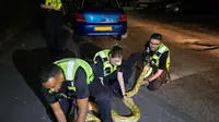 Petugas kepolisian Bromwich Barat sedang bekerja sama mengevakuasi ular piton Burma. (Instagram/@westmidlandspolice)