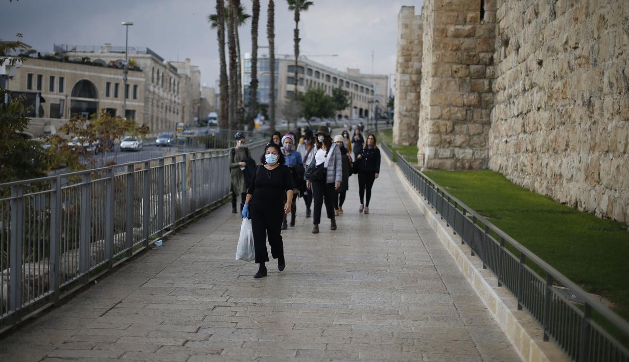 Orang-orang yang mengenakan masker terlihat di luar Kota Tua Yerusalem di tengah pandemi COVID-19 (25/11/2020). (Xinhua/Muammar Awad)