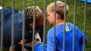 Pemain Brasil, Neymar mencium putranya, Davi Lucca di sela sesi latihan di Sochi, Rusia, Jumat (29/6). Neymar mengajak putranya saat mengikuti latihan bersama Timnas Brasil di Piala Dunia 2018. (Adrian DENNIS/AFP)