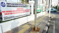 Spanduk pemberitahuan peniadaan salat id terpasang di Jalan Matraman Raya, Jakarta, Minggu (24/5/2020). Adanya pandemi Covid-19 menyebabkan kegiatan salat id 1441 H di lokasi tersebut ditiadakan. (Liputan6.com/Immanuel Antonius)