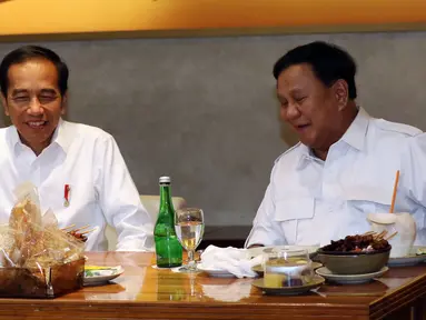 Presiden terpilih Joko Widodo atau Jokowi (kiri) makan siang bersama Ketua Umum Partai Gerindra Prabowo Subianto di FX Sudirman, Jakarta, Sabtu (13/7/2019). Jokowi dan Prabowo terlihat penuh tawa saat menyantap sate dan kelapa muda. (Liputan6.com/JohanTallo)