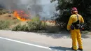 Petugas pemadam kebakaran melihat api yang membakar kawasan sebelah Otay Lakes Road di dekat Highway 94, California, Amerika Serikat, Sabtu (20/5). Kebakaran tersebut melahap lahan seluas 1000 hektar. (AP Photo/Hayne Palmour IV)