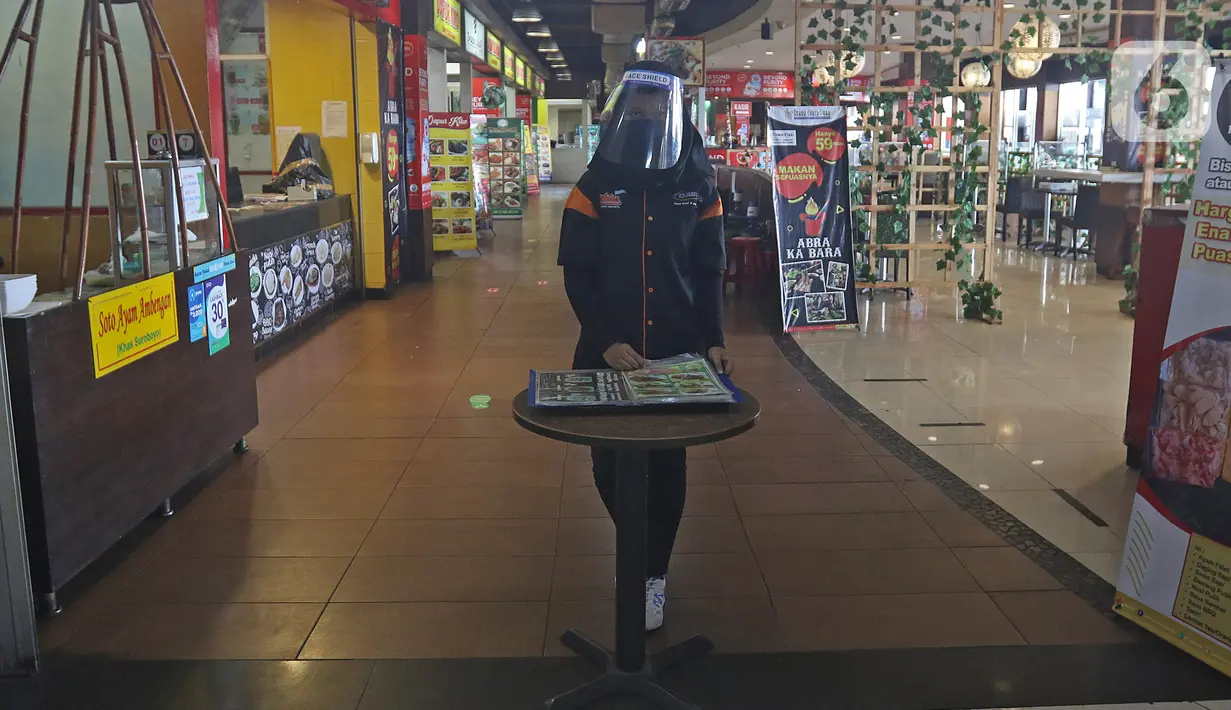 Petugas menggunakan face shield berjaga di salah satu restoran Mall Bekasi, Jawa Barat, Minggu (7/6/2020). Sejumlah tempat makan mulai menerapkan protokol kesehatan untuk pengunjung yang makan ditempat untuk mencegah penyebaran wabah COVID-19. (Liputan6.com/Herman Zakharia)