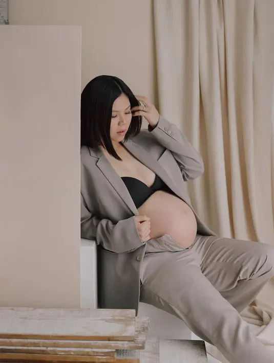 Greysia tak ragu pamer baby bump di trimester ketiga kehamilan mengenakan blazer warna mocca dan bra hitam. [Foto: cr/@bennylims/@juniapics].