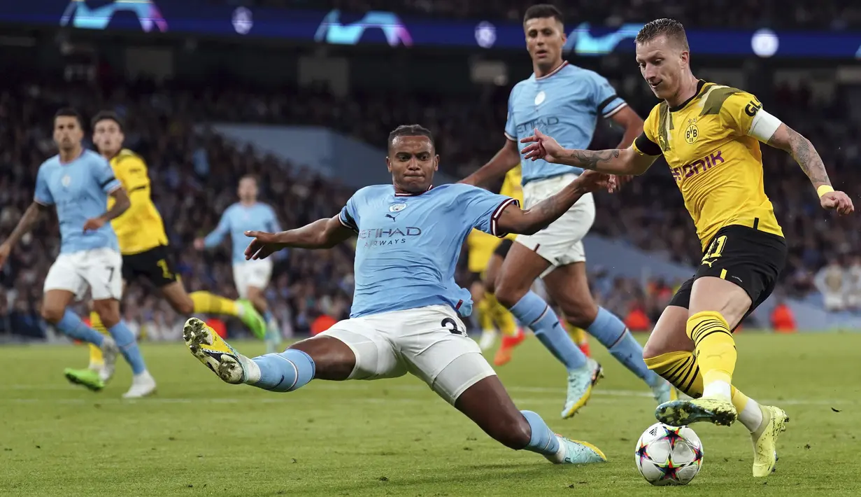 Bek Manchester City Manuel Akanji mencoba menghadang penyerang Borussia Dortmund Marco Reus pada laga kedua Grup G Liga Champions di Etihad Stadium, Manchester, Kamis (15/9/2022) dini hari WIB. Menjamu Borussia Dortmund di matchday kedua Liga Champions, Manchester City menang dramatis 2-1 setelah sempat tertinggal lebih dulu. (Tim Goode/PA via AP)