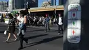 Warga melintasi penyebrangan dekat Petunjuk sinyal lalu lintas untuk pejalan kaki yang baru ditampilkan pada tiang dekat Stasiun Flinders Street pada Hari Perempuan Internasional di Melbourne, Australia, Rabu (8/3). (AFP Photo / Paul Crock)