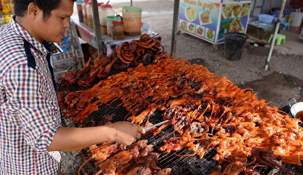 Pedagang memanggang tikus untuk dijual di provinsi Battambang (8/8/2019). Tikus bakar bukanlah makanan yang lezat untuk dinikmati, tetapi di provinsi pedesaan Battambang, Kamboja, mereka populer sebagai camilan murah dan cepat. (AFP Photo/Tang Chhin Sotthy)