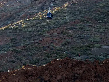 Wisatawan yang terperangkap di kereta gantung dievakuasi di Gunung El Teide, Taman Nasional El Teide, Pulau Canary, Spanyol, Rabu (15/3). Sekitar 60 wisatawan terperangkap di dua kereta gantung saat menuju puncak Gunung El Teide. (Desiree Martin/AFP)