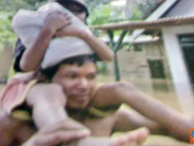 Citizen6, Trenggalek: Seorang bapak menggendong anaknya untuk mengungsi dari banjir yang semakin meninggi.