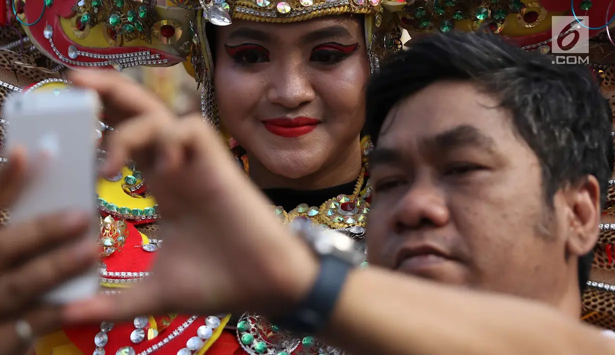 Pengunjung berselfie dengan kelompok seni budaya Kalimantan Selatan saat pelaksanaan car free day di Jakarta, Minggu (1/7). Pawai tersebut diadakan untuk mengenalkan budaya Kalimantan Selatan kepada masyarakat. (Liputan6.com/Immanuel Antonius)