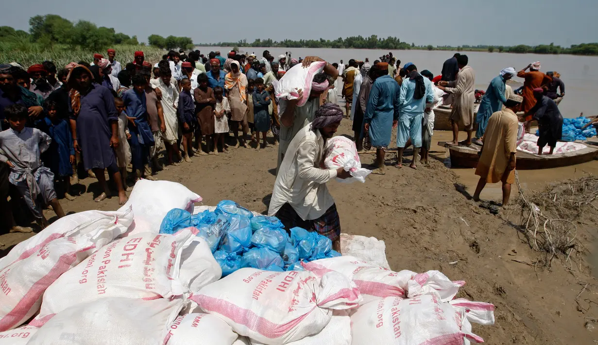 Korban banjir saat menerima bantuan Yayasan Edhi di Distrik Ghotki, Sindh Pakistan, Rabu (7/9/2022).Pekerja bantuan memperingatkan kurangnya pasokan air minum bersih yang menyebabkan peningkatan penyakit di Pakistan, karena korban tewas akibat banjir melewati 1.200 jiwa.(AP Photo/Fareed Khan)