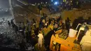 Tim SAR dibantu warga mencari korban di reruntuhan pabrik berlantai lima yang ambruk di Lahore, Pakistan Timur, Rabu (4/11) malam waktu setempat. Sedikitnya 16 orang tewas dan 40 luka-luka akibat kejadian tersebut. (AFP PHOTO/Arif Ali)