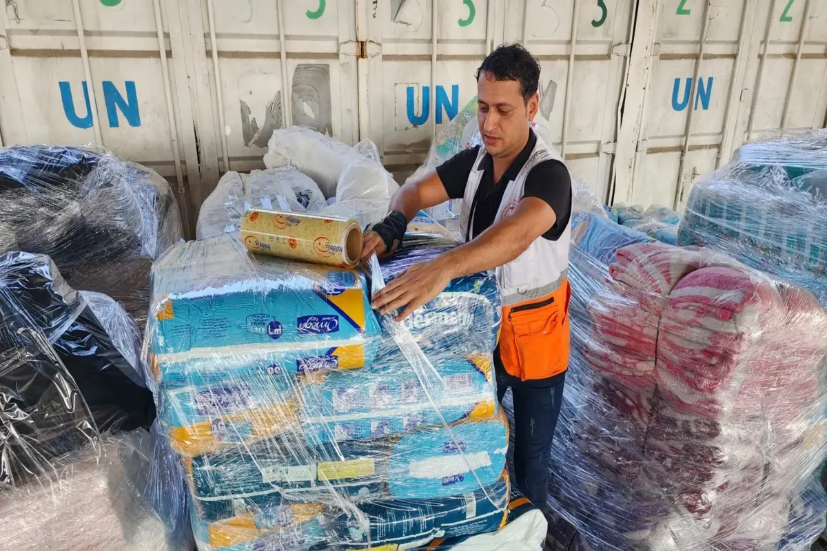Seorang pekerja PBB menyiapkan bantuan untuk didistribusikan kepada warga Palestina di gudang UNRWA di Deir Al-Balah, Jalur Gaza, pada 23 Oktober 2023. (AP)