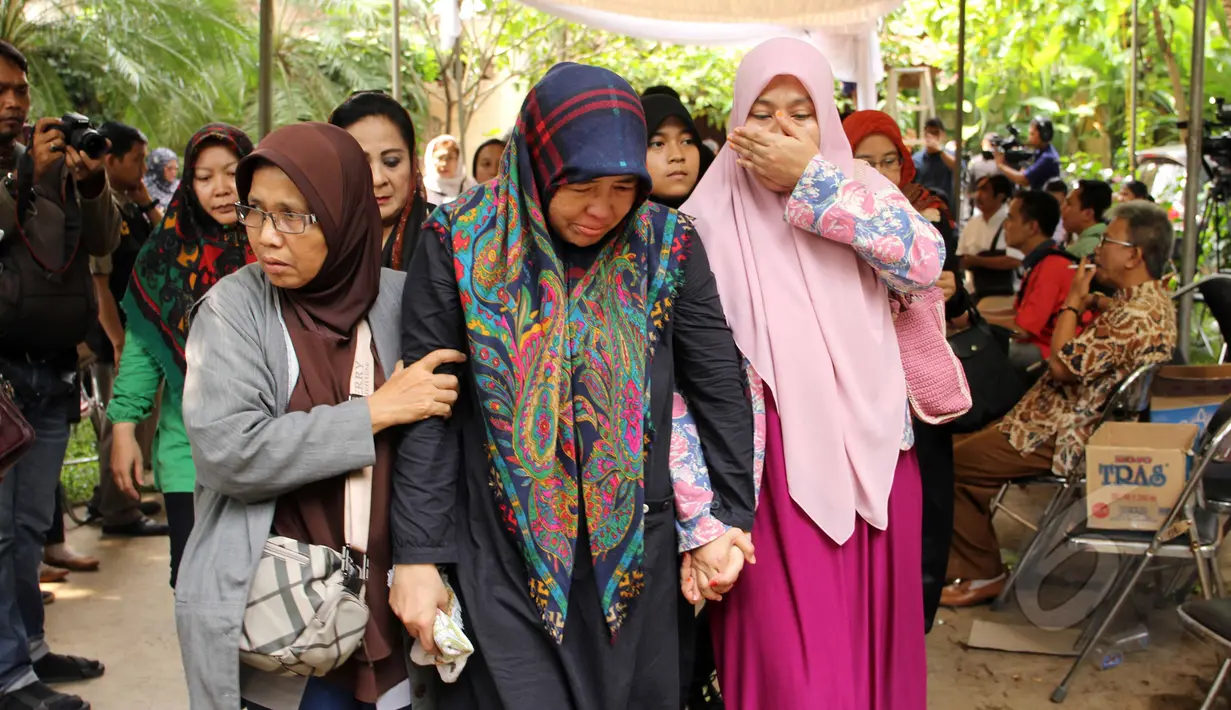 Uce Sriasih (tengah) istri Didi petet berjalan didampangi keluarganya di rumah duka di kawasan Ciputat, Tangsel, Jumat (15/5/2015). Didi Petet meninggal di usia 58 tahun. (Liputan6.com/Helmi Afandi)