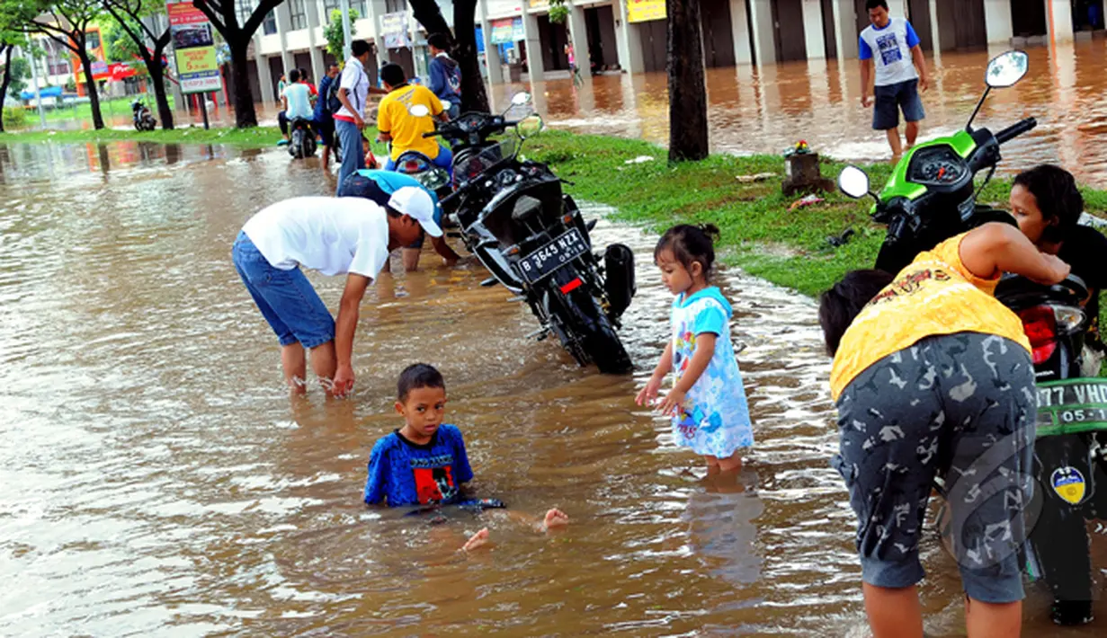 Hujan yang turun sejak Minggu (8/2), mengakibatkan kawasan perumahan Garaharaya di Tangerang, Banten terendam air. Beberapa warga memanfaatkan genangan air untuk membersihkan sepeda motor, Selasa (10/2/2015). (Liputan6.com/Faisal R Syam)