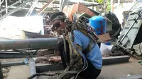 Manusia robot dari Bali menggerakkan tangan yang lumpuh dengan mesin. (Liputan6.com/Dewi Divianta)