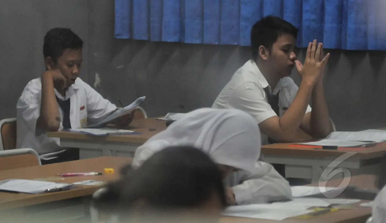 Sejumlah siswa terlihat serius mengerjakan soal Ujian Nasional (UN) di SMPN 29 Jakarta, Senin (5/4/2015). UN tingkat SMP tersebut diikuti 149.172 peserta. (Liputan6.com/Johan Tallo)