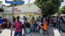 Para pembeli berdiri dengan tas berisi barang-barang yang mereka beli di Dajabón, Republik Dominika, sebelum melintasi perbatasan ke Haiti, Kamis, 14 September 2023. (AP Photo/Ricardo Hernández)