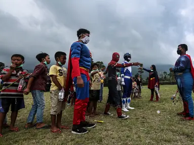 Anak-anak saat bermain dengan relawan berkostum superhero di Tempat Pengungsian Gunung Merapi, Desa Klakah, Selo, Boyolali, Jawa Tengah, Sabtu (21/11/2020). Kegiatan bermain ini untuk mengisi waktu anak-anak sehingga dapat menjaga kondisi anak tetap ceria dan sehat. (Liputan6.com/Johan Tallo)