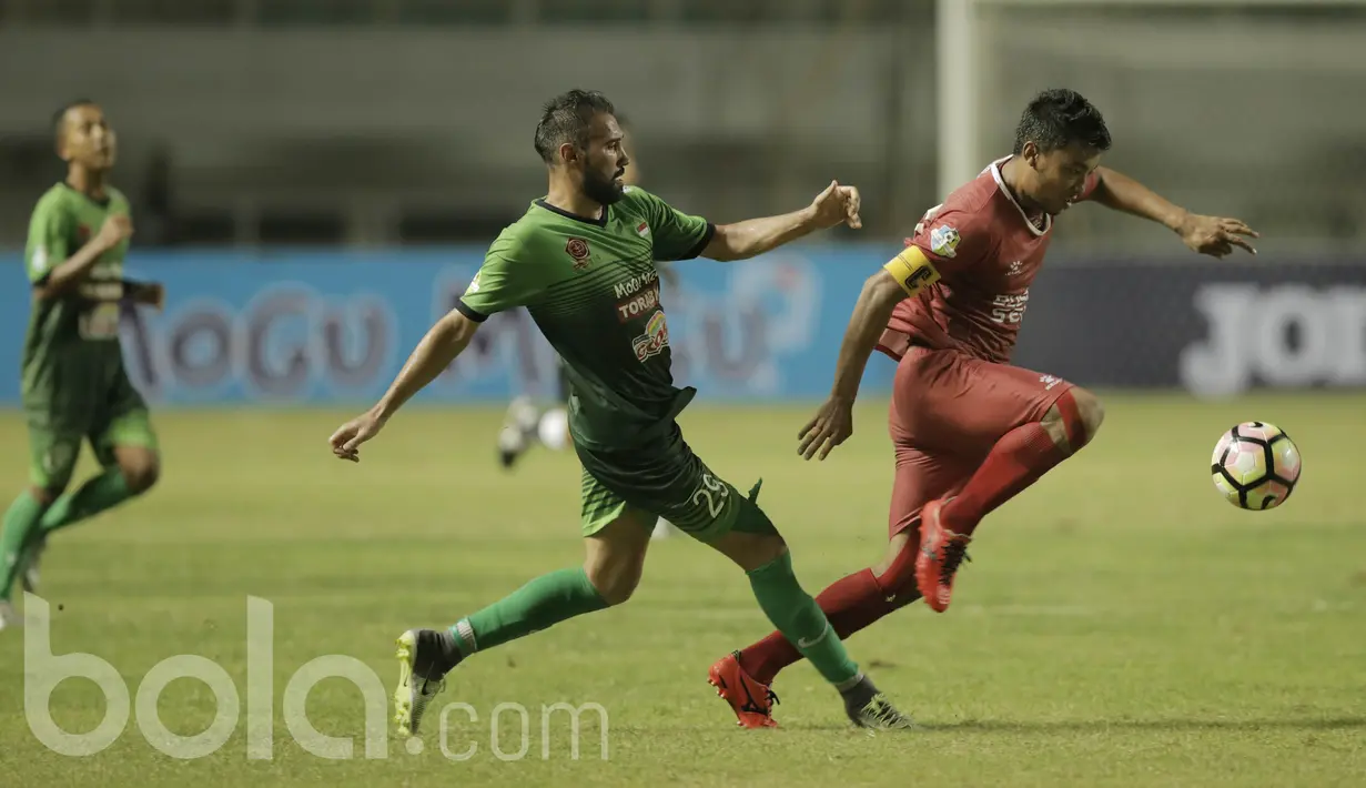 Pemain PS TNI, Elio Martins, berusaha menghadang kapten PSM, Hamkah Hamzah pada laga Liga 1 Indonesia di Stadion Pakansari, Bogor (15/05/2017). PS TNI menang 2-1. (Bola.com/M Iqbal Ichsan)