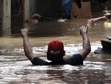 Warga melintasi banjir di Jalan Kebon Pala, Kampung Melayu, Jatinegara, Jakarta Timur, Rabu (7/2). Setelah sempat surut, banjir kembali merendam permukiman warga dengan ketinggian air mencapai sekitar 170 cm. (Liputan6.com/Arya Manggala)