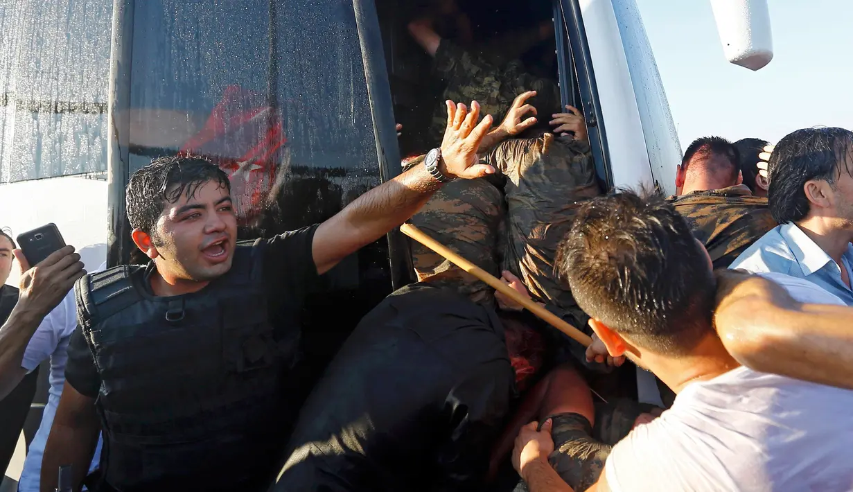 Warga membawa kayu untuk mengarahkan pukuannya ke para tentara yang masuk kedalam bus di Jembatan Bosphorus, Istanbul , Turki, (16/7). Tentara berebutan masuk kedalam bus untuk menyelamatkan diri dari pukulan warga. (REUTERS / Murad Sezer)