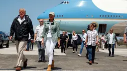 Presiden AS Donald Trump dan ibu negara Melania Trump setibanya di Luis Muniz Air National Guard Base, Puerto Rico, Selasa (3/10). Trump tiba di Puerto Rico untuk menyaksikan langsung kehancuran akibat terjangan Badai Maria dua pekan lalu. (AP/Evan Vucci)