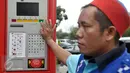 Juru parkir berada di dekat mesin terminal parkir elektronik (TPE) di Jalan Ir H Juanda, Jakarta, Senin (24/10). Pemprov DKI resmi menerapkan sistem pembayaran parkir pinggir jalan (on street) dengan TPE. (Liputan6.com/Yoppy Renato)