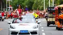 Kontestan Miss World dari El Savador tersenyum sambil membawa bendera China saat mengikuti pawai menggunakan supercar di Sanya, Provinsi Hainan, China, (7/11). Pawai ini membuka kontes kecantikan Miss World ke-67. (AFP Photo/Str/China Out)