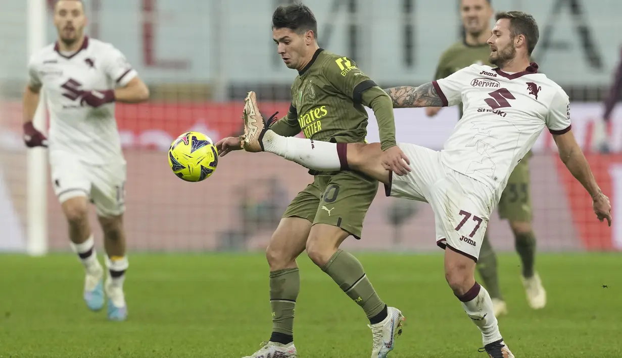 Gelandang AC Milan Brahim Diaz (tengah) berebut bola dengan gelandang Torino Karol Linetty dalam duel pekan ke-22 Serie A 2022-2023, Sabtu (11/2/2023) dini hari WIB. Milan sementara naik ke posisi tiga dengan 41 poin dari 22 laga, satu poin di depan AS Roma yang baru bermain 21 kali. (AP Photo/Antonio Calanni)