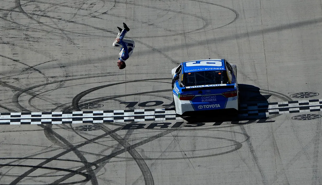 Pembalap Carl Edwards melakukan aksi gila dengan salto dari mobil ketika mesin dalam keadaan berjalan perlahan usai merayakan kemenangan NASCAR Sprint Cup Series Food City 500 di Bristol Motor Speedway (17/4). (AFP/Matt Sullivan)
