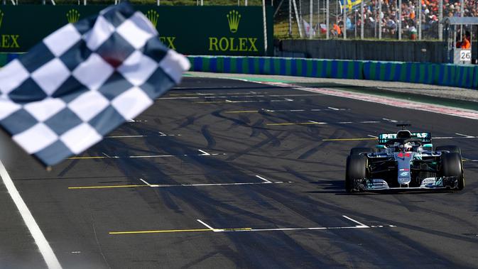 Lewis Hamilton saat berhasil finish diurutan pertama GP Hungaria di Sirkuit Hungaroring, Mogyorod, (29/7). Hamilton berhasil menjaga selisih 24 poin dari pesaing terdekatnya, pebalap Ferrari, Sebastian Vettel. (Andrej Isakovic/Pool Photo via AP)