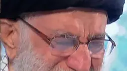 Pemimpin Tertinggi Iran, Ayatollah Ali Khamenei menangis saat berdoa atas jenazah Mayor Jenderal Qassem Soleimani di Universitas Teheran, Senin (6/1/2020). Qassem Soleimani tewas setelah menjadi target serangan drone AS di Bandara Internasional Baghdad beberapa hari lalu. (Iran Press TV via AP)