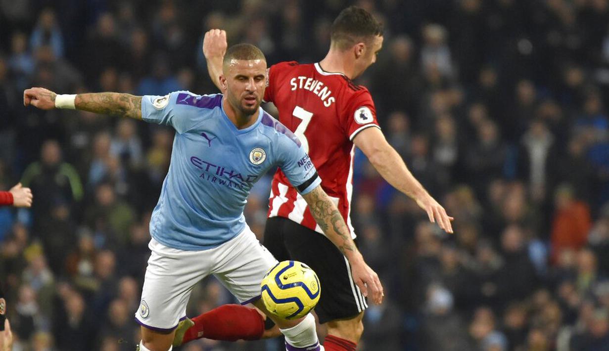 Bek Manchester City, Kyle Walker, berebut bola dengan pemain Sheffield United, Enda Stevens, pada laga Premier League 2019 di Stadion Etihad, Minggu (30/12). Manchester City menang 2-0 atas Sheffield United. (AP/Rui Vieira)