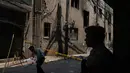 Seorang polisi berjaga saat warga setempat berjalan melewati gedung restoran dan hotel yang terbakar di New Delhi, India, Rabu 3 Juni 2026. (AP Photo/Manish Swarup)